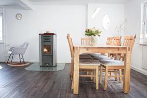 ein Esszimmer mit einem Tisch und einem Holzofen in der Unterkunft Bergkrönchen Winterberg - Sauna - 8Beds - outdoor in Winterberg