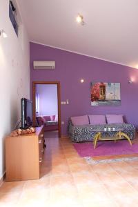 sala de estar con paredes de color púrpura y sofá en Apartman Precca en Supetarska Draga