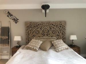 - un lit avec une tête de lit en bois et des oreillers dans l'établissement La Casita Alta Free Parking, à Noordwijk aan Zee