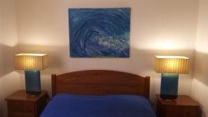 a bedroom with two lamps and a bed with a painting at Bungalow Beach in Brejao