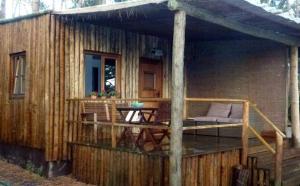 a small wooden house with a deck and a table at Bungalow Beach in Brejao