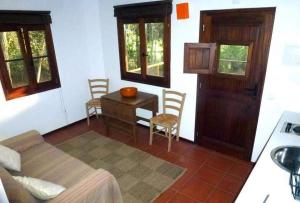 a bedroom with a bed and a table and a door at Bungalow Beach in Brejao