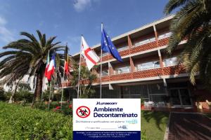 a sign in front of a building with flags at Hotel Marina in Marina di Massa