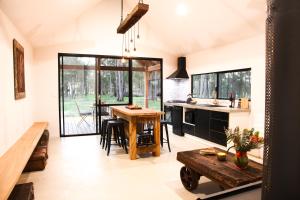 a kitchen and living room with a table and a counter at Littlewood Chalet in Margaret River Town