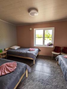 um quarto com duas camas e uma janela em Kihnu Külalistemaja em Lemsi