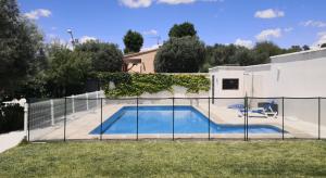 a fence around a swimming pool in a yard at Casa Las Olivas in Toledo