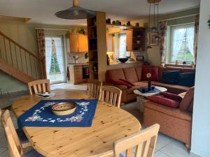 a kitchen and living room with a wooden table and chairs at Ferienhaus 8 an der Ostsee in Schönhagen in Brodersby OT Schönhagen