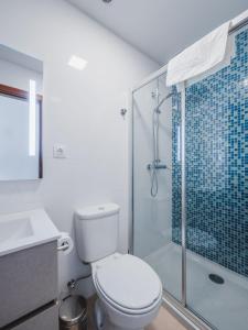 uma casa de banho com um WC e uma cabina de duche em vidro. em Nature Madeira Guest House em Porto da Cruz
