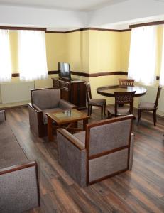 ein Wartezimmer mit Stühlen, Tischen und einem TV in der Unterkunft Hotel St. Naum in Ljubaništa