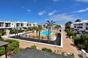 kompleks apartamentów z basenem i palmami w obiekcie Villa Papagyo w mieście Playa Blanca