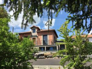 a large orange house with a balcony at La Mésange in Millau