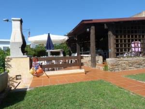 een patio met een bank en een parasol voor een gebouw bij Villetta La Ginestra in Stintino