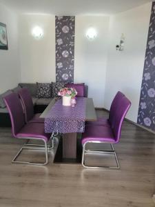 stół i purpurowe krzesła w salonie w obiekcie Miroslav w Bašce