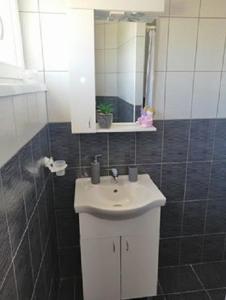 W łazience znajduje się biała umywalka i lustro. w obiekcie Miroslav w Bašce
