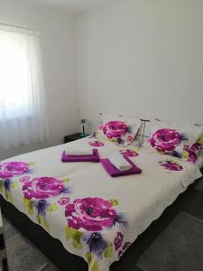 łóżko z różowymi kwiatami na górze w obiekcie Miroslav w Bašce