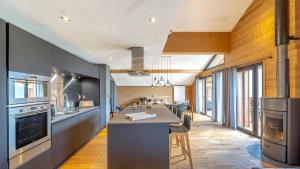 eine große Küche mit einer langen Theke mit Stühlen in der Unterkunft Les 360 - Apt 8 - BO Immobilier- remises sur les forfaits de skis Châtel ou Portes du soleil in Châtel