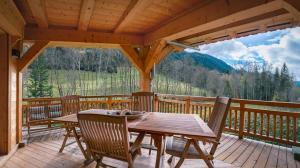 a wooden porch with a table and chairs on a deck at Les 4 Chamois - Chalet - BO Immobilier in Abondance