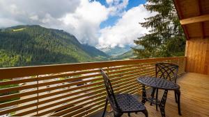 zwei Stühle und ein Tisch auf einem Balkon mit Aussicht in der Unterkunft Les 360 - Apt 8 - BO Immobilier- remises sur les forfaits de skis Châtel ou Portes du soleil in Châtel