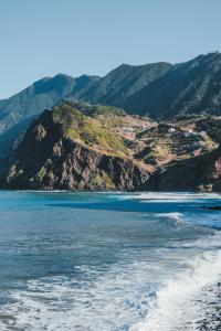 ポルト・ダ・クルースにあるNature Madeira Guest Houseの山々を背景にビーチを望む