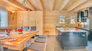 a kitchen with a long table with chairs and a counter at Les 4 Chamois - Chalet - BO Immobilier in Abondance