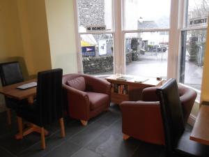 a waiting room with chairs and a table and a window at The Bay House Lake View Guest House - Adults Only in Bowness-on-Windermere