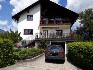 ein Auto, das vor einem weißen Haus parkt in der Unterkunft Ferienwohnung Daniela in Bad Aussee