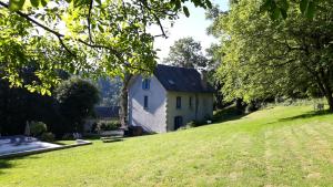 uma casa numa colina com um jardim relvado em B&B "Le Parc des 4 Saisons" em Corrèze