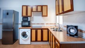 a kitchen with a refrigerator and a washing machine at Cotillo Sea 2 in Cotillo