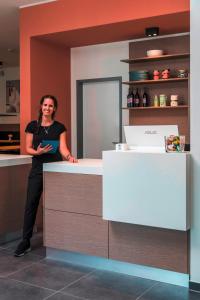 a woman standing at a counter in a kitchen at Mintrops Concierge Hotel in Essen