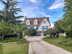 een huis met een onverharde weg ervoor bij La maison bleue in Corpeau