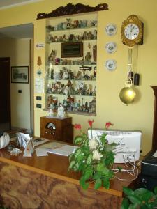 Habitación con escritorio y reloj en la pared. en Albergo Il Gufo, en Parma