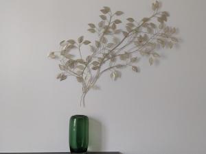 a green vase on a table with a plant on the wall at Berge du Rhône, Centre Lyon, espace de travail, tout à pied, Université Lyon 2 et Lyon 3, idéal voyage d'affaires, tourisme, loisirs in Lyon +29 photos