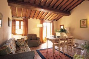 ein Wohnzimmer mit einem Sofa und einem Tisch in der Unterkunft Il Defizio in Gambassi Terme