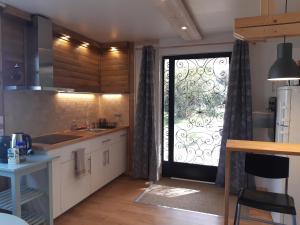 een keuken met een grote glazen deur en een raam bij La maison bleue in Corpeau