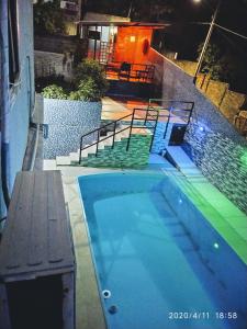 basen w nocy ze schodami i budynek w obiekcie Casal.20 Studios Flats w mieście Cabo de Santo Agostinho