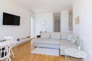 een witte woonkamer met een bank en een tafel bij Appartamento in posizione centrale con vista mare e parcheggio in Caorle