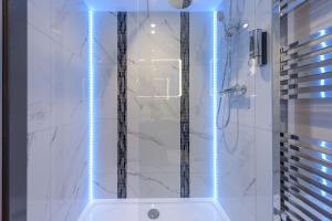 La salle de bains est pourvue d'une douche avec des lumières bleues. dans l'établissement The Stanley Hotel, à Boston