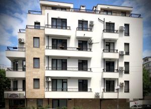 ein weißes Gebäude mit Fenstern und Balkonen in der Unterkunft Sunny Shore Burgas Apartment in Burgas City