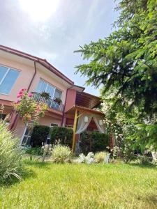a pink house with a lawn in front of it at Casa Constantin si Elena ( Adults only ) in Eforie Nord