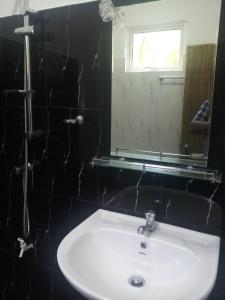 Cassia Udawalawe في اوداوالاوي: حمام مع حوض أبيض ومرآة