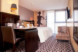 a hotel room with a bed and a desk and a chair at The Vincent Hotel in Southport