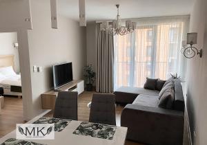 a living room with a couch and a tv at MK Angel Apartment in Krakow