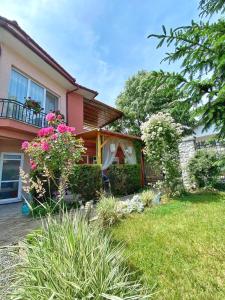 a house with a yard with flowers in front of it at Casa Constantin si Elena ( Adults only ) in Eforie Nord