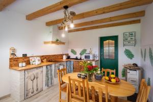 a kitchen with a wooden table and chairs at Domek Na Polanie in Budzów