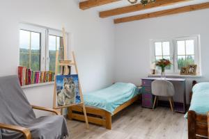 a room with a bed and a painting of a dog at Domek Na Polanie in Budzów