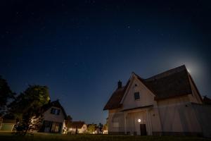 Una casa blanca de noche con un cielo estrellado en Luxusferienhaus Fuchsbau - mit Netflix, PlayStation, Sauna, Sportraum und Kamin en Zirchow