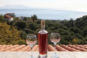 two wine glasses sitting on a ledge with a bottle of wine at Studios Argyri in Agios Kirykos