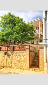 un edificio con una escalera frente a un edificio con un árbol en Shmagdas House Sighnaghi შმაგდას სახლი სიღნაღში en Sighnaghi
