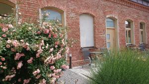 a brick building with a bush of pink roses at Maison am Liesingbach in Vienna