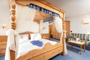 una camera con un grande letto a baldacchino in legno di Hotel Gries a Canazei